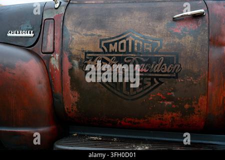 Harley-Davidson logo painted on a rusty Chevrolet hot rod door at Race to the Waves 2026, Bridlington South Beach Stock Photo