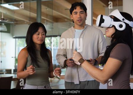 Diverse coworkers demonstrating virtual reality in modern meeting room with white VR headset Stock Photo