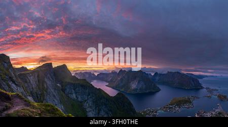 Spectacular panoramic aerial sunset view over Reine village and Reinefjorden from summit of Reinebringen mountain in Lofoten Islands, Norway. Stock Photo