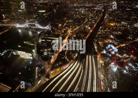Aerial view of a train station at night with illuminated platforms and ...