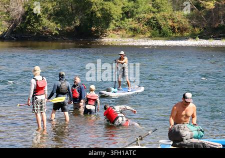 White water rafters and paddleboarders prepare to launch their craft on the Deschutes River at the crowded Trout Creek launch area and campground near Stock Photo
