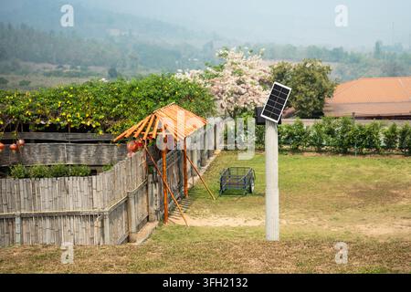 Cheap ecological solar energy in rural farm, small solar panel mounted on pole in countryside. Stock Photo