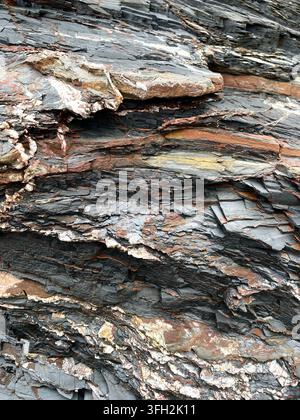 Full frame vertical background of worn and weathered natural slate rock in layers and a blue grey colour with copy space Stock Photo