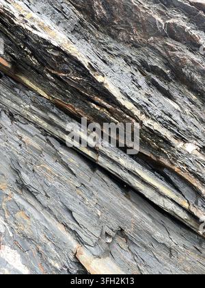 Full frame vertical background of worn and weathered natural slate rock in layers and a blue grey colour with copy space Stock Photo