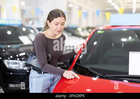 woman choosing a new car in a car dealership Stock Photo