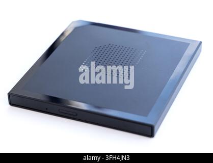 A black external optical drive with a perforated top rests on white Stock Photo