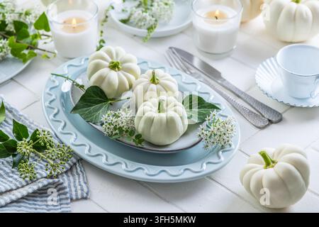 Elegant autumn table setting with white pumpkins and delicate greenery Stock Photo