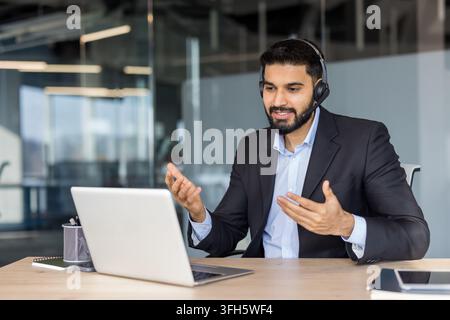 Professional man in suit having a video conference call on laptop. Stock Photo
