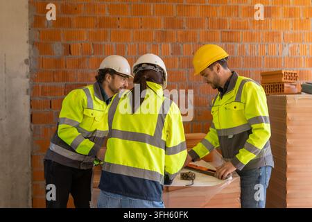 Team of architects analyzing technical blueprints Stock Photo