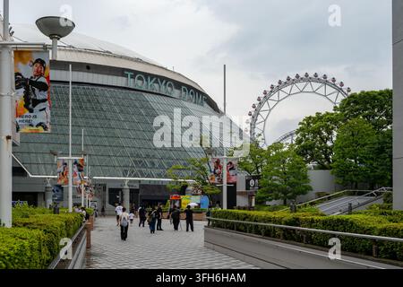 Tokyo, Japan - July 17, 2026: Tokyo Dome and the Big O Ferris wheel at Tokyo Dome City, with Yomiuri Giants advertising, visitors and the Thunder Dolp Stock Photo