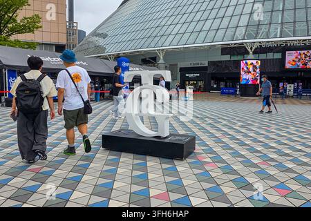 Tokyo, Japan - July 17, 2026: Tokyo Giants TG logo sculpture outside Tokyo Dome, with visitors, event displays and stadium facilities around the entra Stock Photo