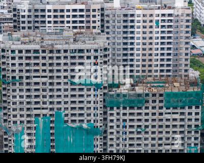 Aerial view of the Punawale construction site featuring high-rise residential buildings under development with green safety netting and scaffolding in Stock Photo