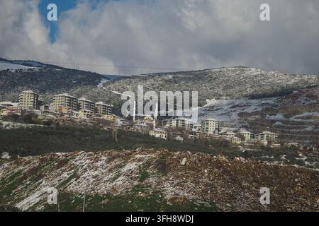 Winter landscape showing a town with buildings and snowy mountains in turkey  Stock Photo