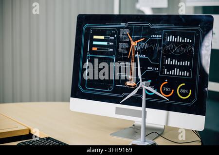 In a modish office, a wind turbine project unfolds on a computer monitor, setting a global standard for environmental governance. Teamwork and innovat Stock Photo