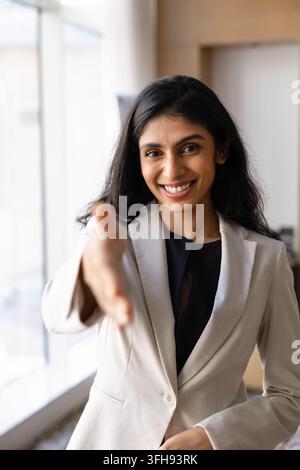Portrait of smiling Indian businesswoman, recruiter extending hand for handshake Stock Photo