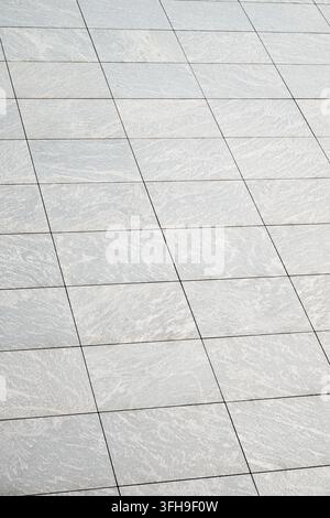Background created using a close-up of modern grey stone block paving. Tile flooring. Stock Photo