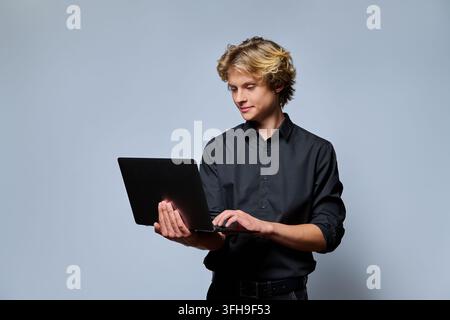 Young businessman working on laptop computer in studio portrait Stock Photo