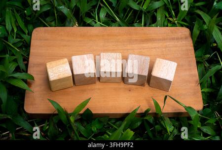 Five Wooden Cubes Aligned on Rustic Wooden Board Flat Lay Concept Stock Photo