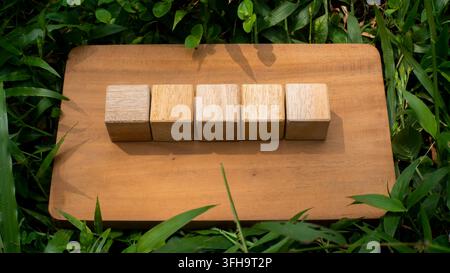 Five Wooden Blocks Aligned on Rustic Wooden Board Flat Lay Concept Stock Photo