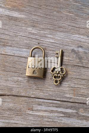 Vintage Love Padlock and Skeleton Key on Weathered Wooden Background Symbolic still life representing love, trust, security, commitment Stock Photo