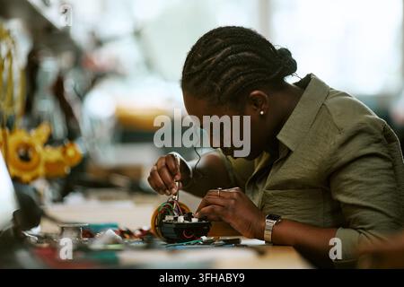 Black Female Engineer Soldering Microchip in Tech Laboratory Stock Photo
