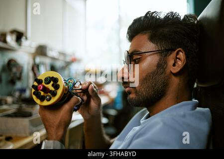 Indian Engineer Assembling Robotic Device in Tech Lab Stock Photo