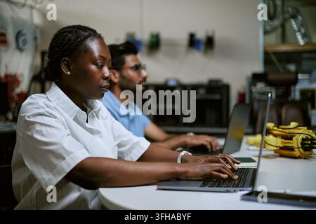 Black Woman Engineer Working on Laptop in Robotics Technology Laboratory Stock Photo
