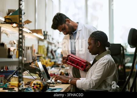 Diverse Engineers Developing Hardware Components in Modern Tech Laboratory Stock Photo
