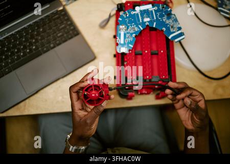 Hands of Black Engineer Assembling Robotic Device in Tech Lab Stock Photo