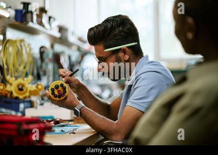 Indian Man Assembling Robotic Hardware Component in Workshop Stock Photo