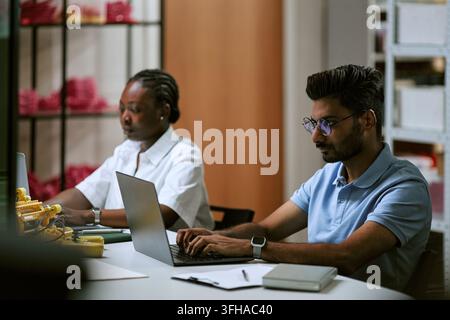 Diverse Colleagues Working on Laptops in Tech Workshop Office Stock Photo