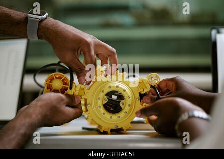 Black Engineers Assembling Yellow Underwater Drone in Laboratory Stock Photo
