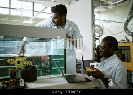 Diverse Engineers Testing Underwater Robot in Laboratory Tank Stock Photo