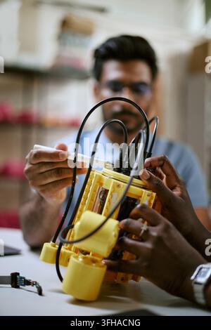 Diverse Engineers Assembling Robotic Prototype in Technology Lab Stock Photo