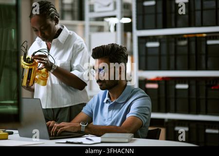 Diverse Engineers Developing Robotic Arm Prototype in Modern Laboratory Stock Photo