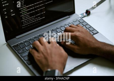 Black Programmer Typing Code on Laptop Keyboard for Software Development Stock Photo