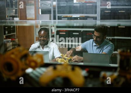 Diverse Engineers Working on Robotics Prototype with Laptops Stock Photo