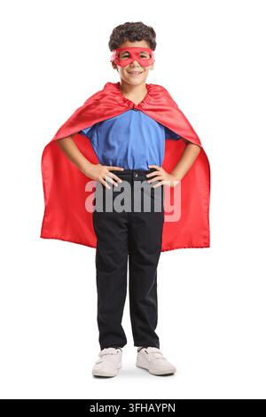Boy in a superhero costume with a red cape and mask isolated on white background Stock Photo