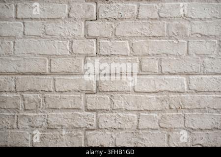 Close-up of a white painted brick wall with distinct mortar lines, providing a textured architectural background. Stock Photo