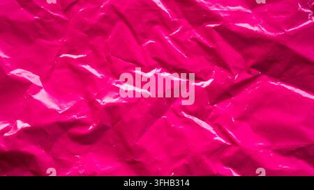 Hot pink crumpled plastic film texture background glossy shiny abstract material surface Stock Photo