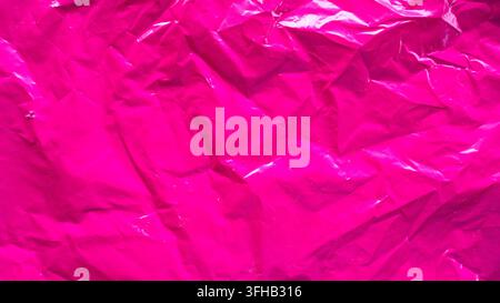 Bright magenta pink plastic bag texture background crumpled glossy cellophane abstract full frame Stock Photo