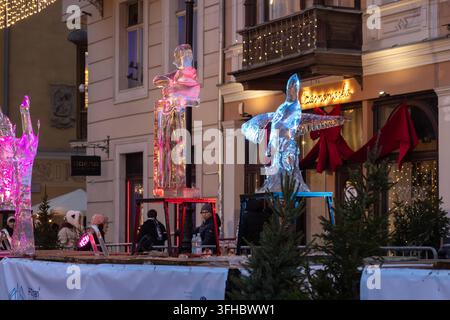Poznan, Poland - December 13, 2025: Artistic ice statues glow with colorful lights on a decorated urban square at twilight, providing a joyful experie Stock Photo