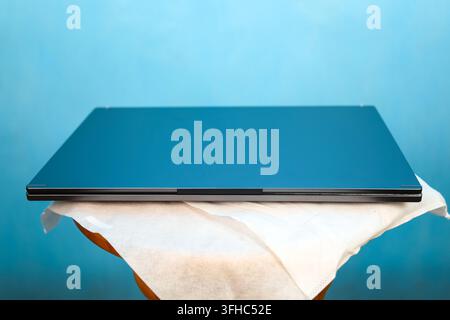 New laptop in factory protective case on blue background. Stock Photo