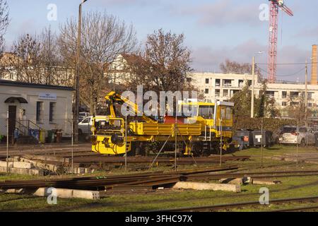 Poznan, Poland - December 15, 2025: PKP Polskie Linie Kolejowe specialized yellow crane vehicle standing on rail tracks at a technical depot near resi Stock Photo
