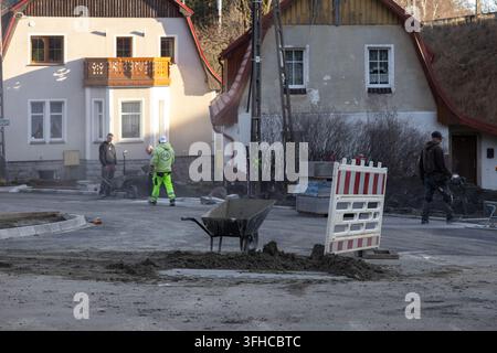 Szklarska Poreba, Poland - December 16, 2025: Dedicated workers building a new residential street, carefully laying paving stones to improve urban inf Stock Photo