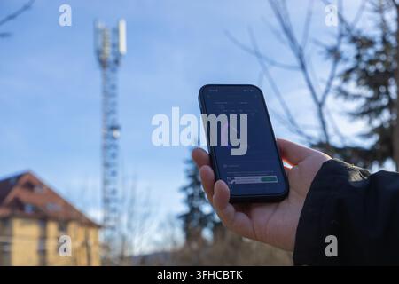 Szklarska Poreba, Poland - December 16, 2025: Hand holds smartphone displaying active 5G network speed test, evaluating mobile internet performance me Stock Photo