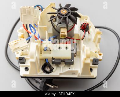 A detailed view shows the internal wiring and motor of an appliance Stock Photo