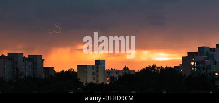 Lightning Over Residential City During Fiery Sunset Stock Photo
