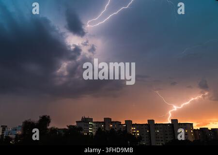 Powerful Lightning Strikes Over Residential City at Sunset Stock Photo