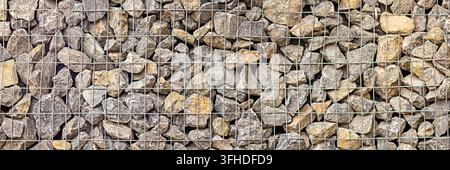 Gabion wall of natural stones in metal wire mesh for landscaping and erosion control Stock Photo